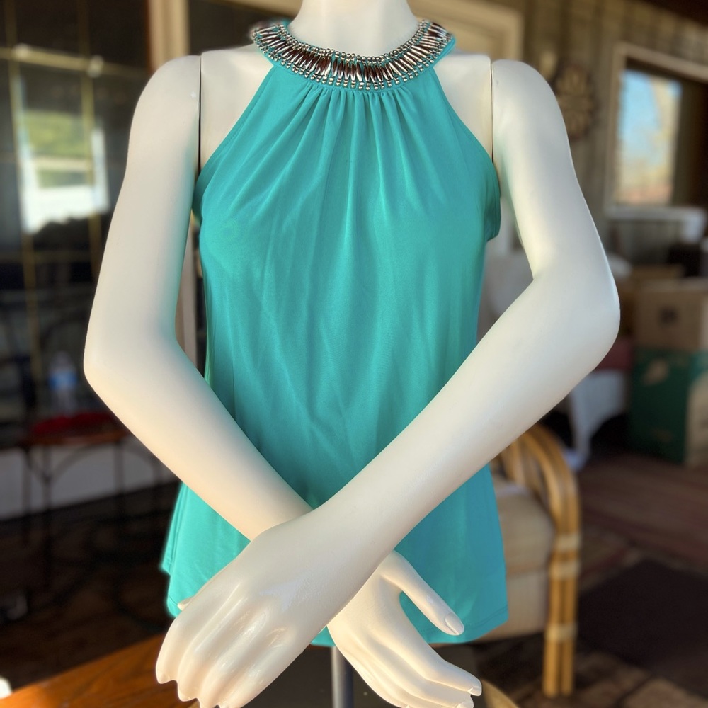 A beautiful turquoise sleeveless blouse with embezzlement around neck